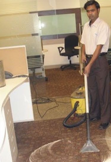 AAGOC housekeeping staff carrying out carpet care in an office